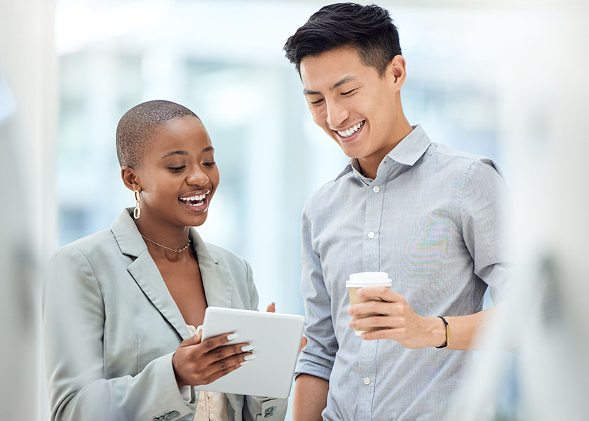 Smiling woman and man looking at tablet